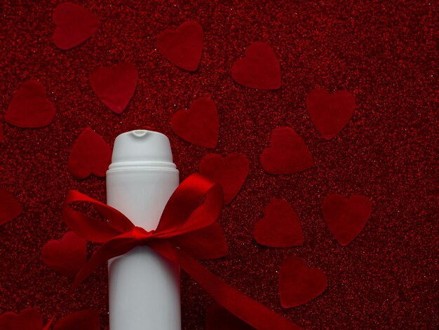 White jar with face cream is on red heart paper background