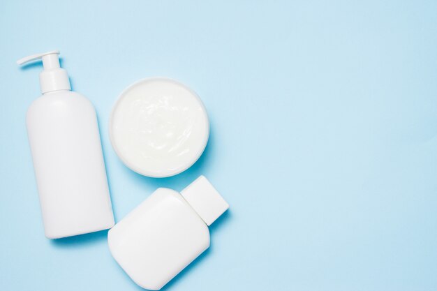 White jars of cosmetics on a blue. Bath accessories.