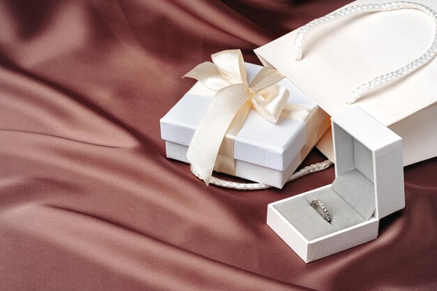 Photo white jewelry boxes on brown silk background