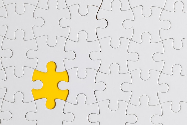 White jigsaw puzzle pieces on a yellow background Business solution concept