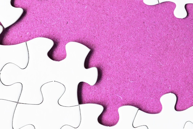 Фото Белая головоломка с некоторыми недостающими кусочками на фиолетовом фоне плоское пространство для копирования