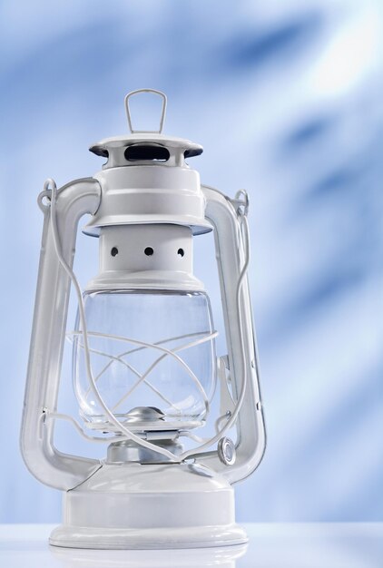 White kerosene lamp on blue background