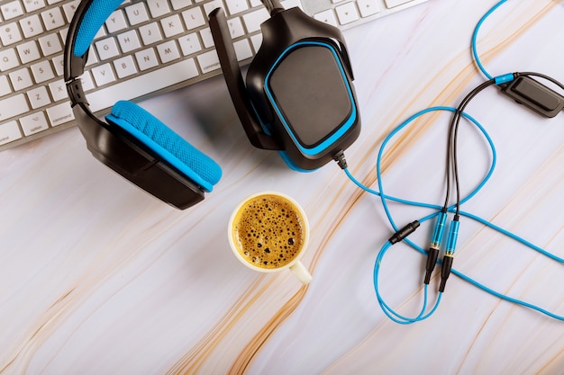 White keyboard computer with headset on a customer support telephone working in call center office desk with cup coffee