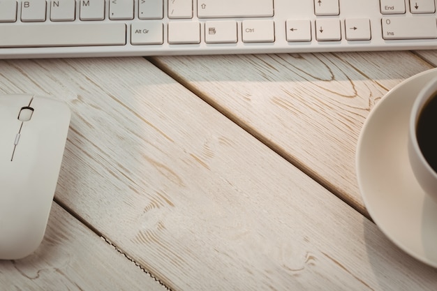 White keyboard and cup of coffee