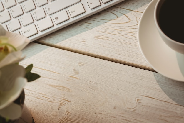 White keyboard and cup of coffee