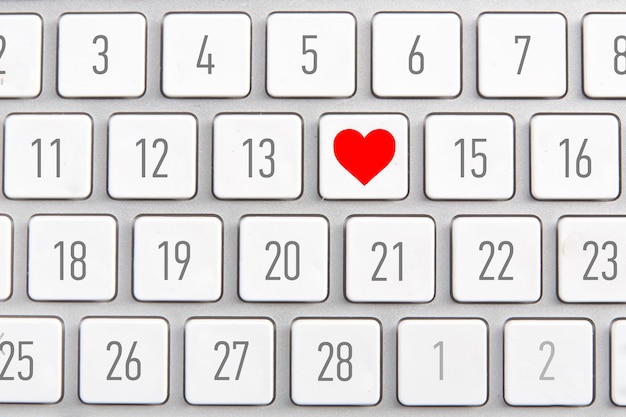 White keyboard with an icon of red heart and calendar on the buttons
