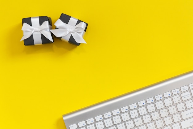 White Keyboard on yellow background with black gifts box