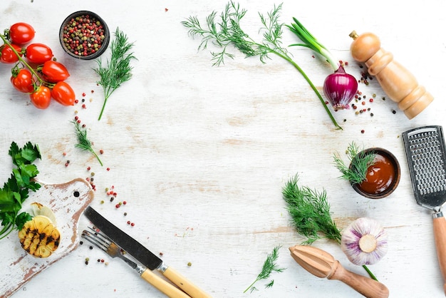 White kitchen background Kitchen board vegetables and spices on a white wooden background Top view