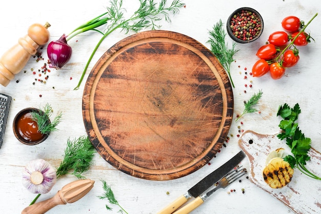 White kitchen background Kitchen board vegetables and spices on a white wooden background Top view