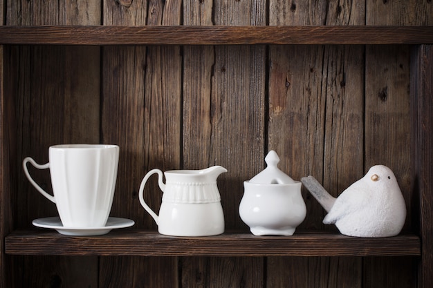 White kitchen dishware on old dark wooden background