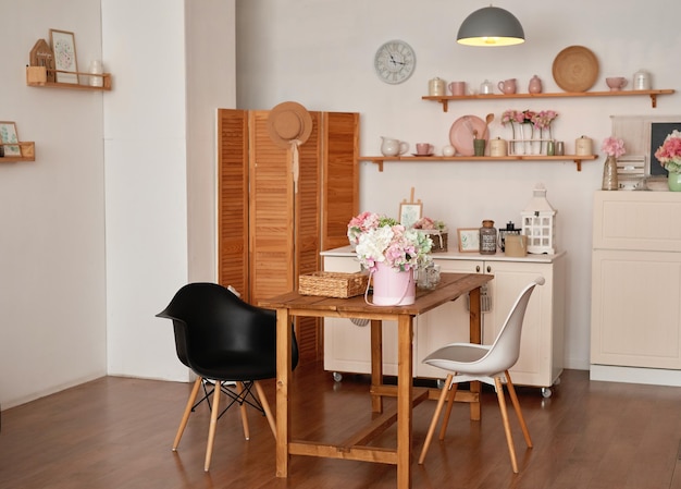 White kitchen interior in loft style Shelves with pink crockery and kitchen utensils Studio apartment Rent and delivery of housing Hostel and hotel