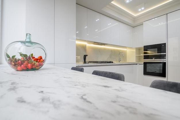 Photo white kitchen interior a vase with fruits at marble counter top