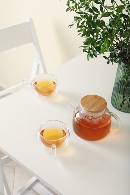 White kitchen table with tea and plant