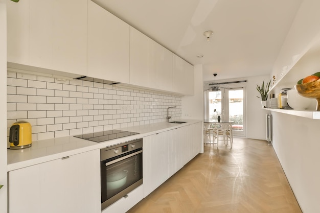 a white kitchen with white cabinets and a wood floor