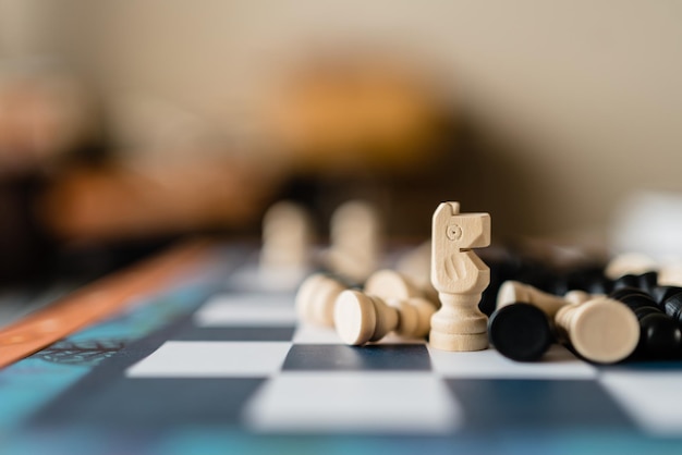 ポーンと他の人が地面にいるチェス盤の上に立っている白い騎士のチェスの駒