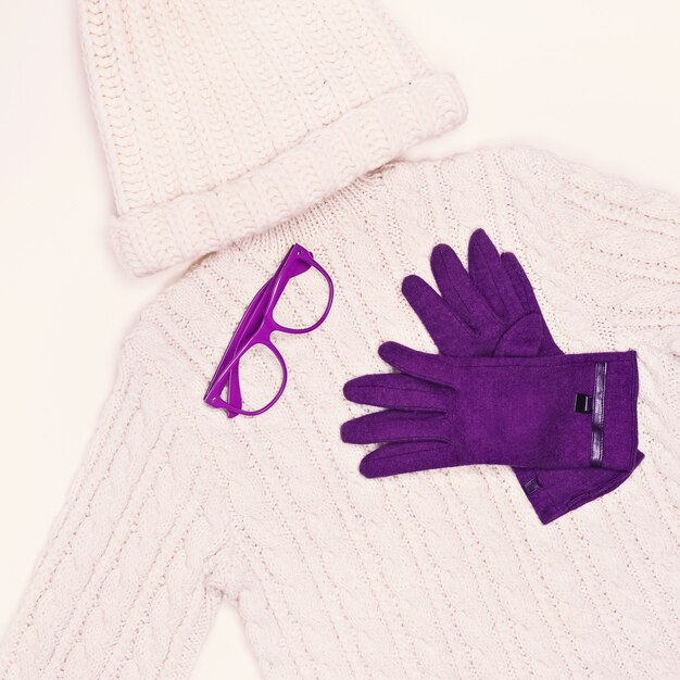 Photo white knit sweater and cap in combination with purple gloves. winter fashion style