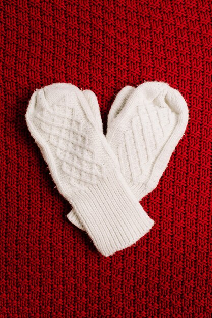 White knitted mittens on red knitted