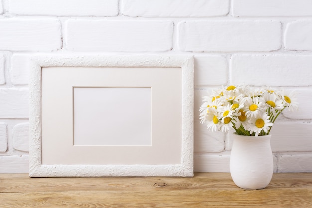 White landscape frame  with chamomile bouquet in rustic vase