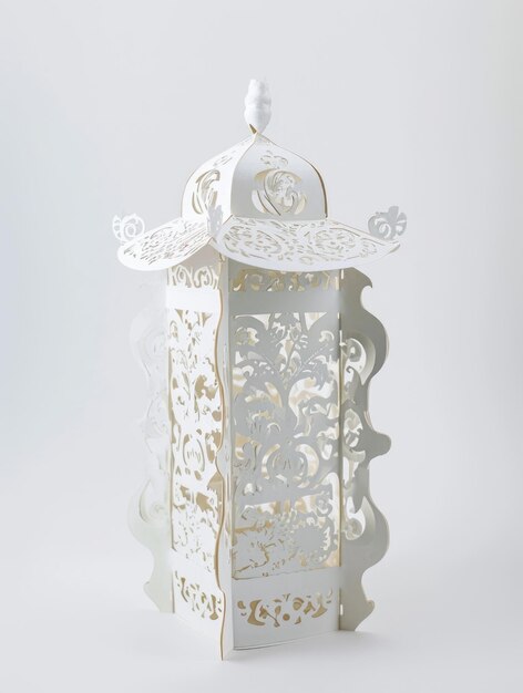 A white lantern with a bird on top of it