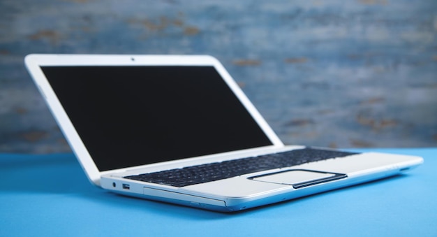 White laptop on the blue business desk