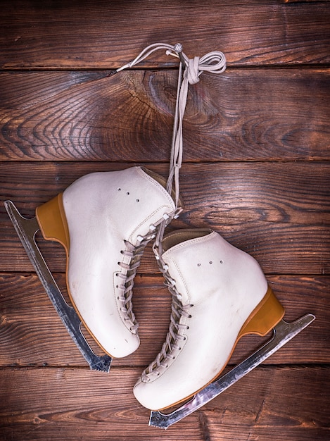 White leather skates hanging on a nail 