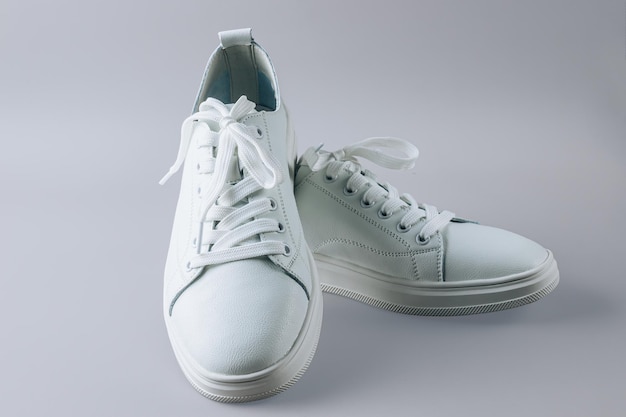 White leather sneakers on gray background