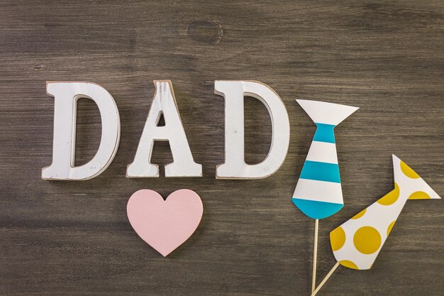White letters DAD on a painted wood background.