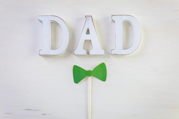 White letters DAD on a painted wood background.