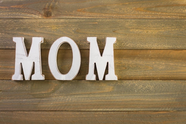 Foto lettere bianche mamma su uno sfondo di legno dipinto.