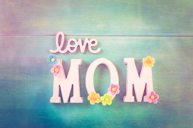 Photo white letters mom on a painted wood background.