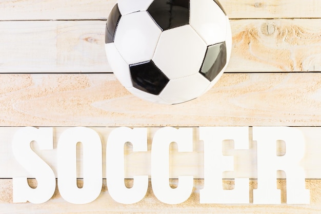 White letters Soccer on a wood background.