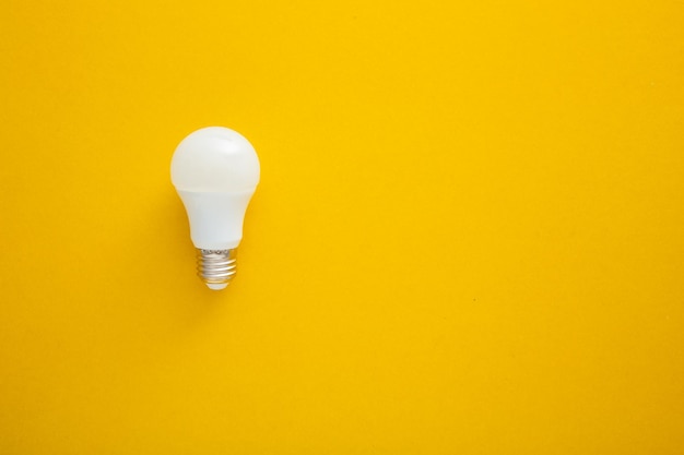 White light bulb on bright yellow background in pastel colors Bright idea concept