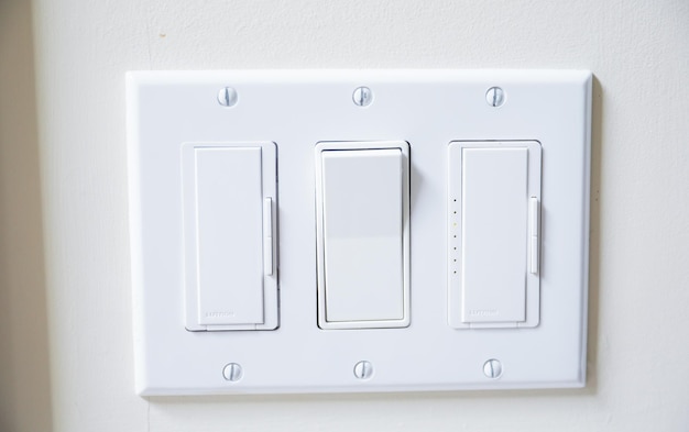 Photo a white light switch with one of the switches on the left and the other one on the right.