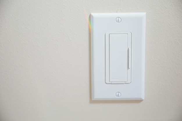 A white light switch with a rainbow light on it.