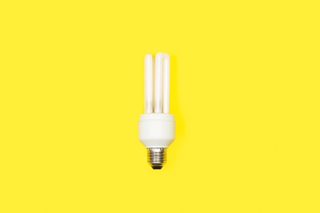 White lightbulb on a yellow background with copy space