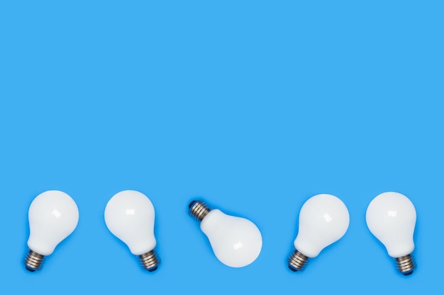 White lightbulbs on a blue background in a top view