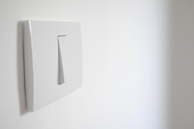 White lighting switch on concrete wall