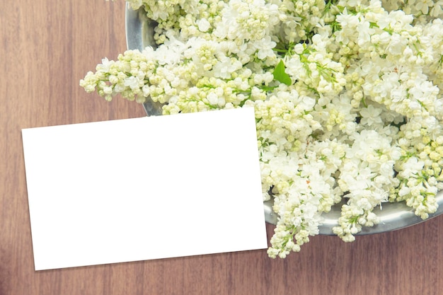 White lilac bowl on a wooden backdrop with business paper card