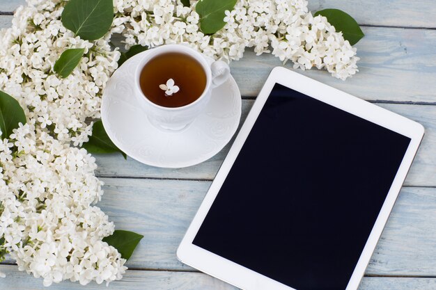  white lilac, a tablet and a cup of tea