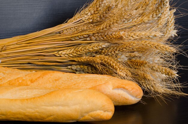 White loaves and a sheaf on a dark surface, close-up