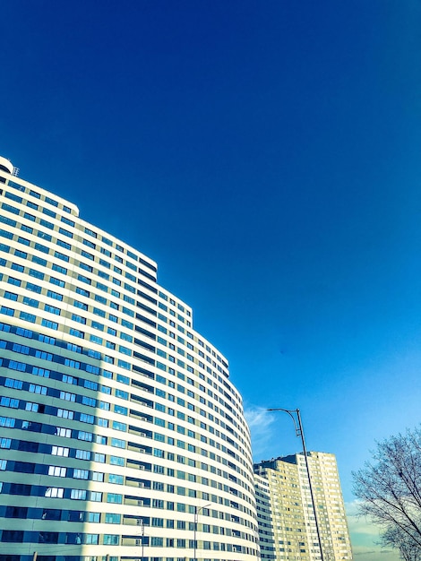 White long house in the form of a wave against a blue bright sky new building of blocks