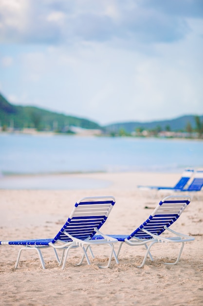 White lounge chairs on a beautiful tropical beach at Maldives