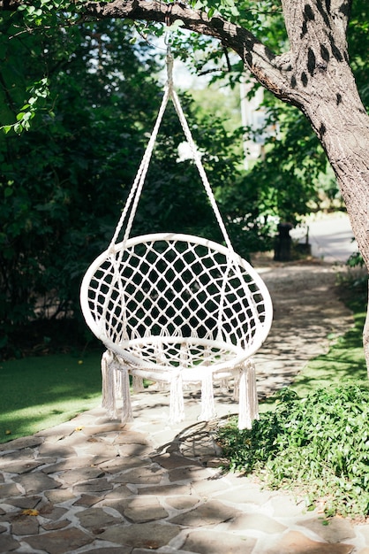 White macrame swing hanging in the garden