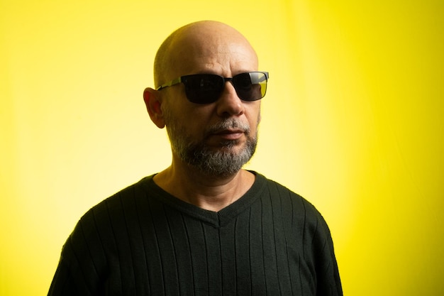 White man bald wearing sunglasses smiling looking at the camera