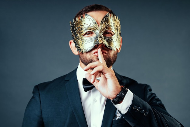 Uomo bianco di aspetto caucasico in giacca nera e camicia bianca con maschera sul viso questo è un ritratto in studio