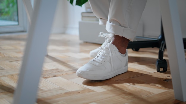 White man shoes sitting chair home closeup Contemporary freelancer legs moving