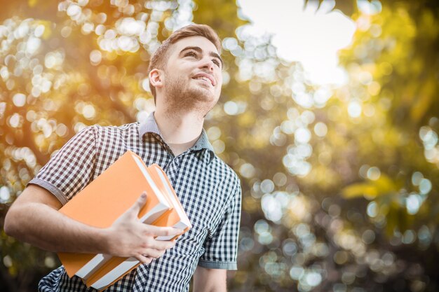 Foto felicità di studente uomo bianco in giardino