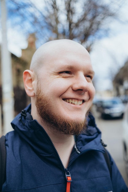 A white man with bald head and beard has a rest in a park