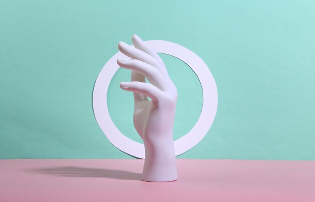 White mannequin hand with circle on bluepink background Minimalism Trendy shadow Creative layout