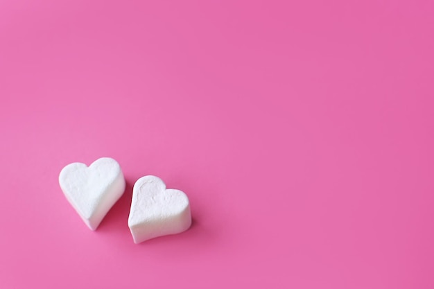 Cuori di marshmallow bianchi su sfondo rosa pastello composizione per la festa della mamma di san valentino